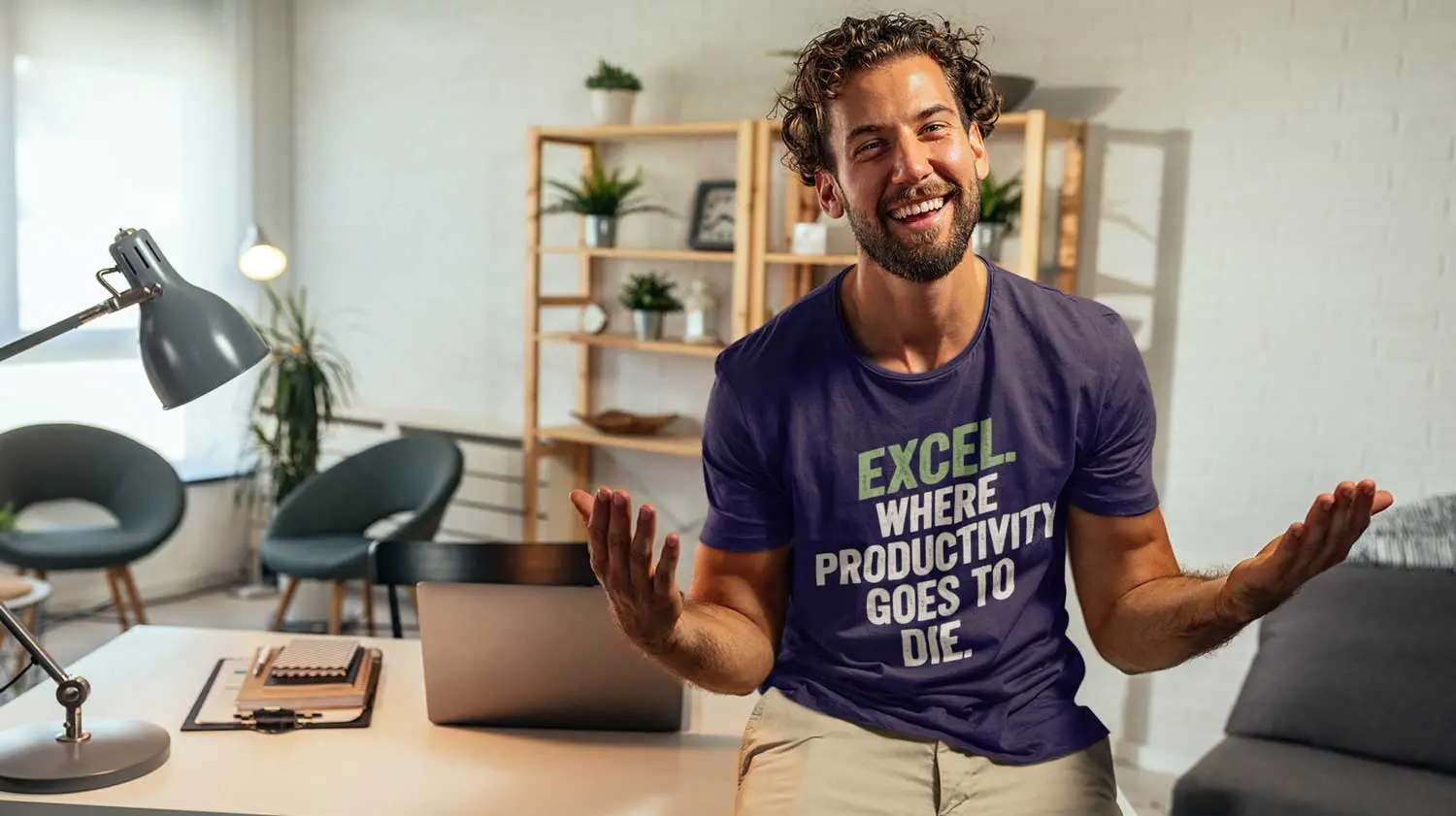 Guy sitting on a office table wearing a T-Shirt from Bored in the Office